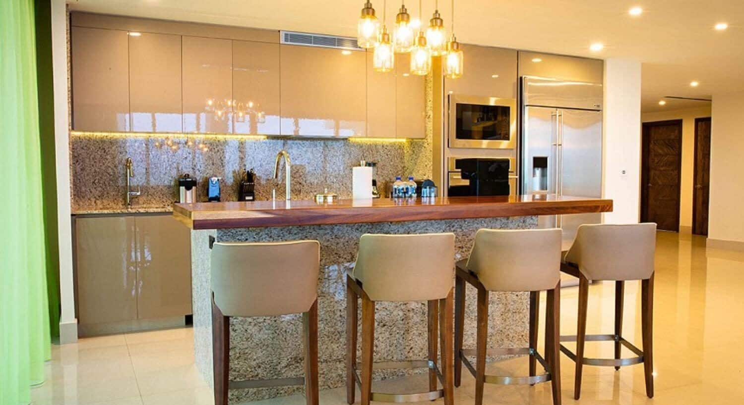 A gourmet kitchen with stainless steel appliances, and a breakfast bar with 4 bar stools.
