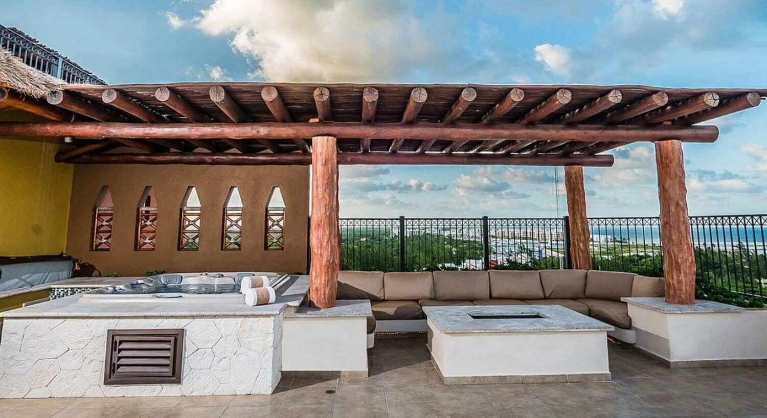 As expansive terrace with an outdoor living area with sofas, a fire pit, and an outdoor hot tub.