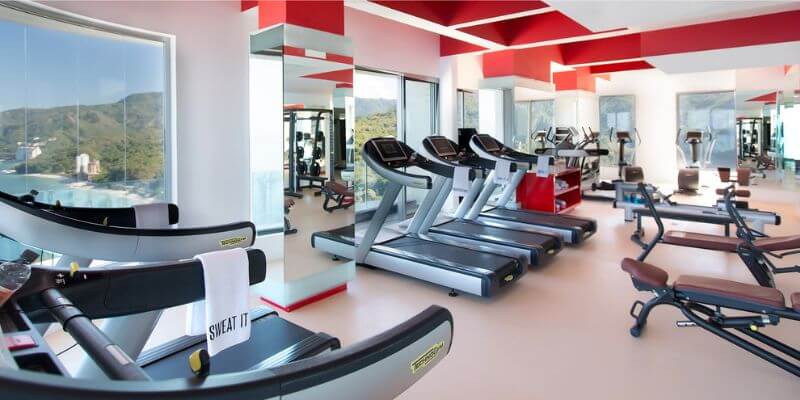 red and black gym equipment with windows showing views of the ocean and mountains