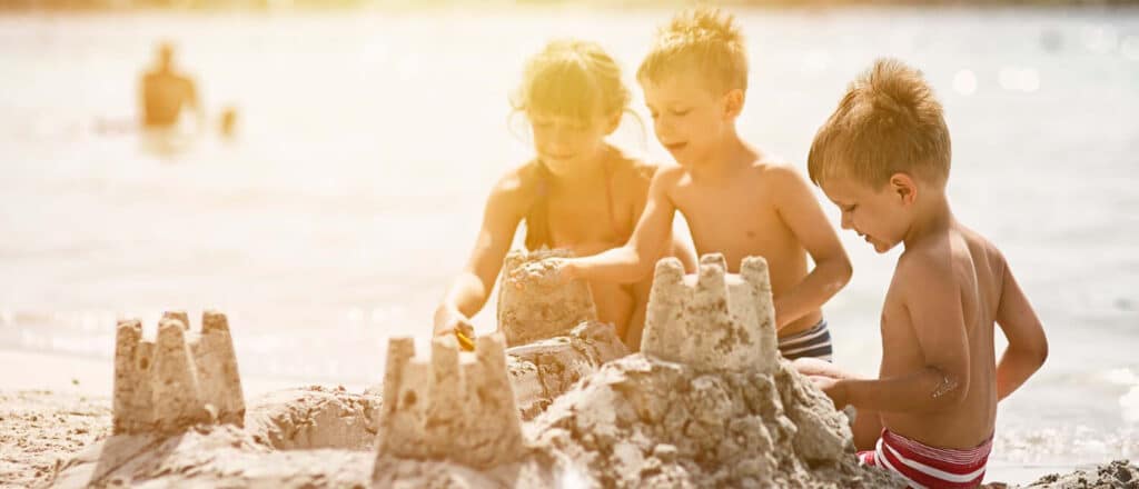 children building sand castles on the beach